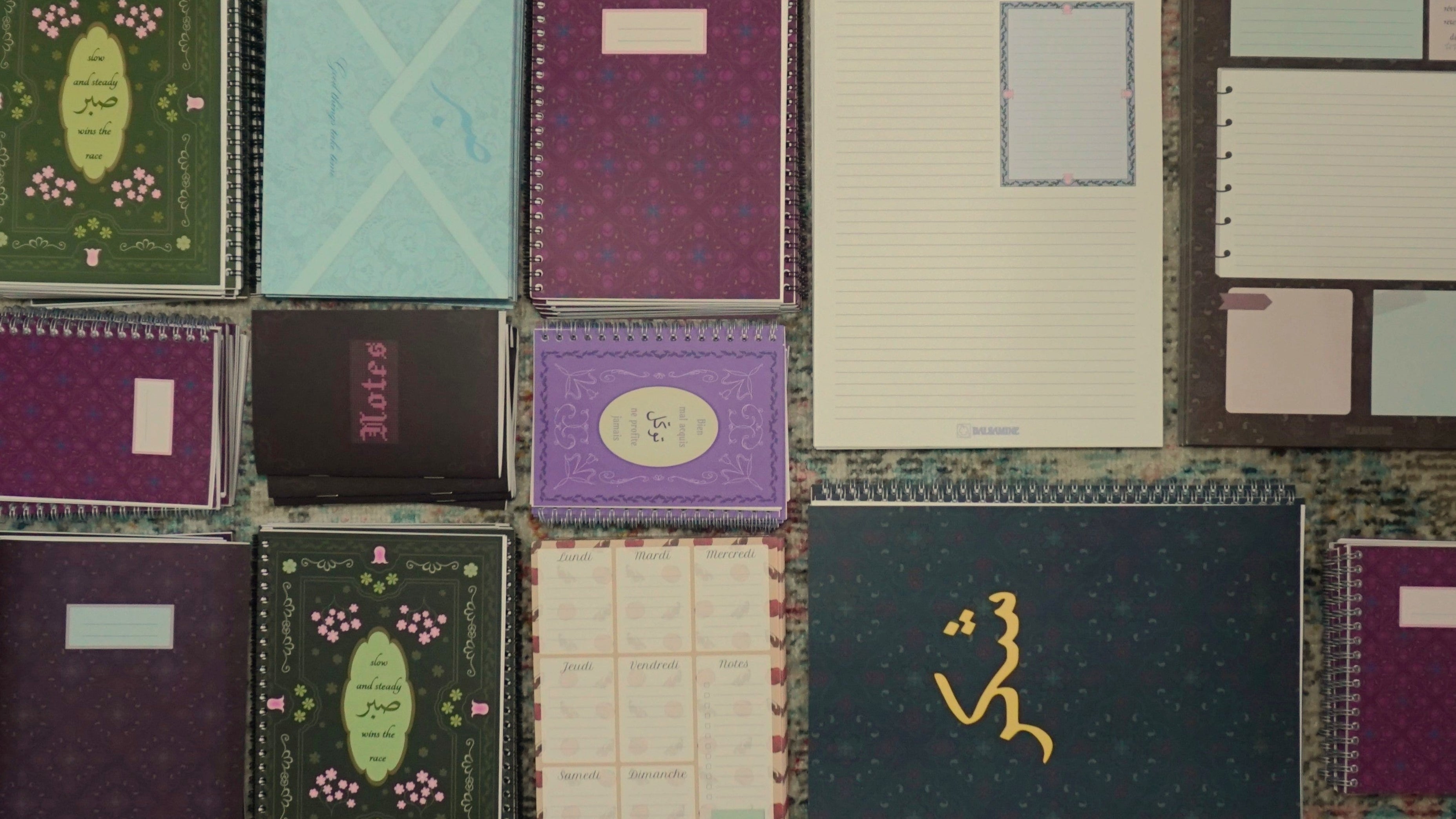 photo de plusieurs produits de la boutique (carnets, cahiers, bloc-notes) sur le sol rangés en blocs de produits
